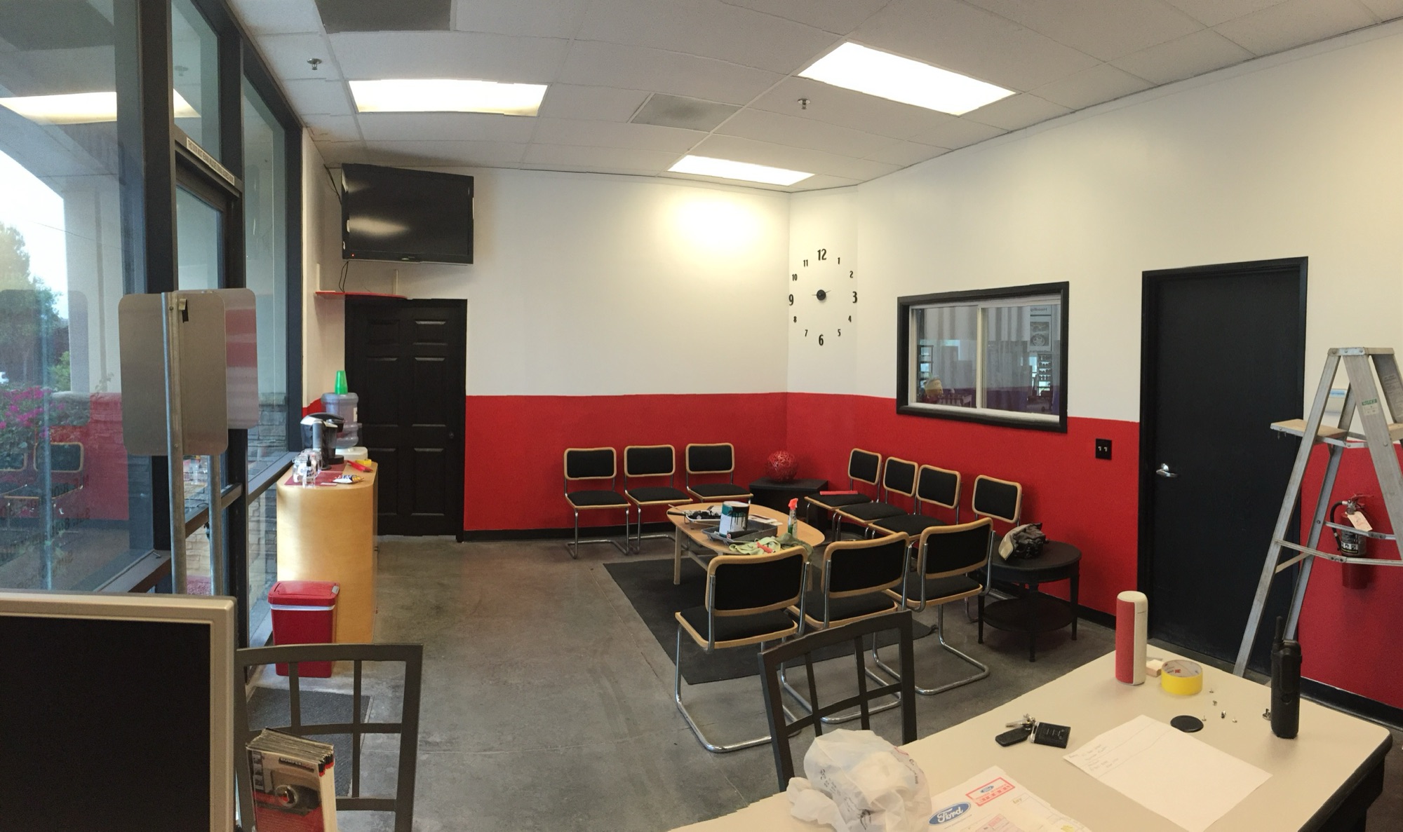 Customer waiting area inside Santee Auto Body with natural light and the service menu